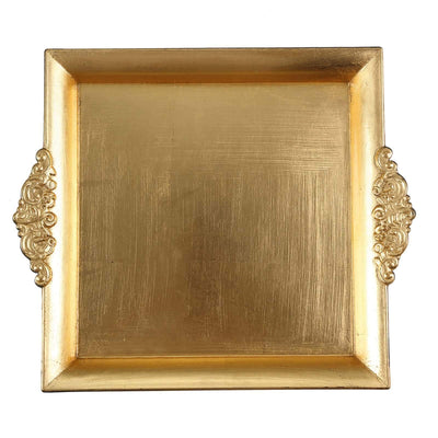 Gold decorative tray with ornate handles on a plain background.