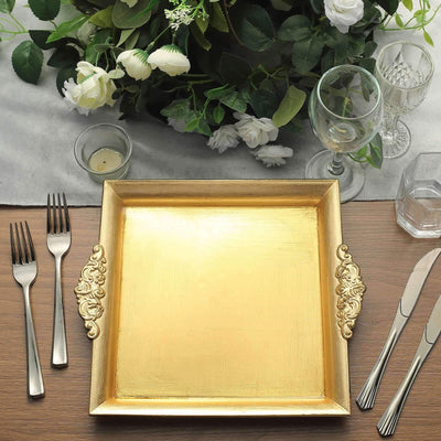 Elegant gold serving tray with decorative handles on a dining table setting.