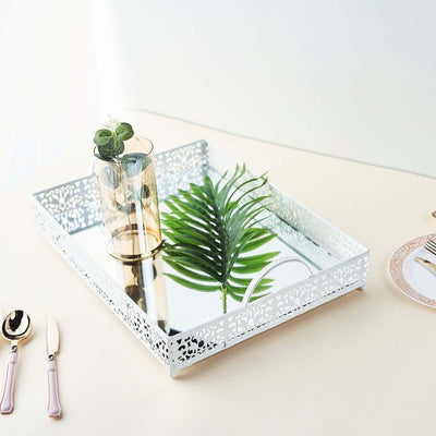 Decorative mirrored tray with greenery and glass vase on a neutral table