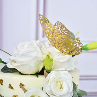 Gold decorative butterfly atop a white floral cake decoration.