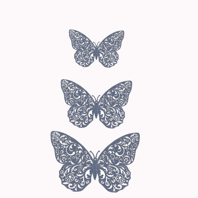 Decorative lace butterfly cutouts in three sizes on a plain background
