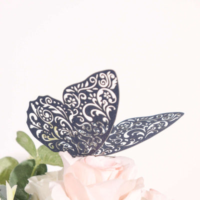 Decorative navy blue butterfly cutout with intricate patterns on floral arrangement