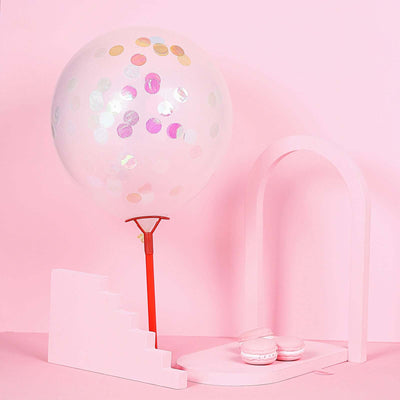 Decorative pink balloon and macarons on a pastel backdrop.