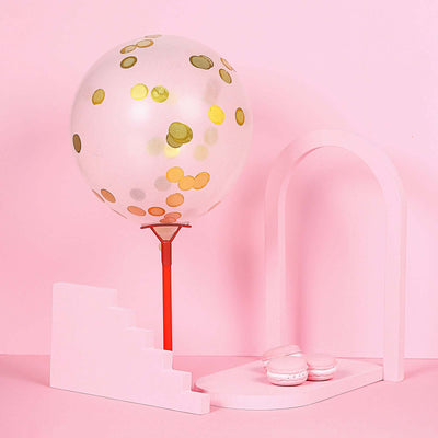 Colorful balloon and pink staircase with macarons on a pastel background.