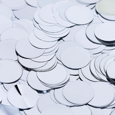Shiny silver mirror circles scattered on a surface.