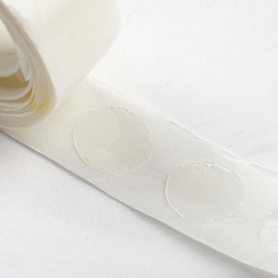 White adhesive dot tape roll on plain background