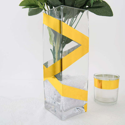 Glass vase with yellow geometric tape design and faux flowers