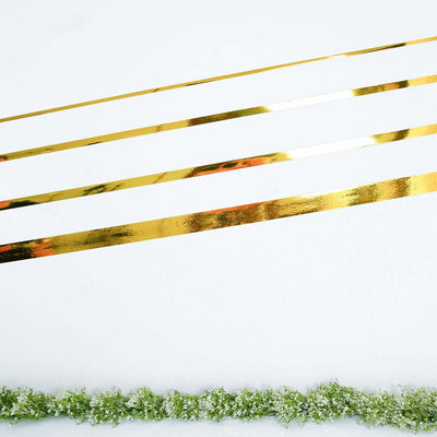 Gold decorative ribbons on a plain background with greenery.