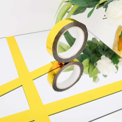 Yellow reflective tape on a mirrored surface with flowers in the background.