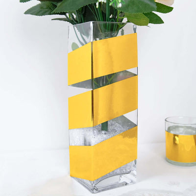 Clear vase with yellow geometric design and artificial flowers