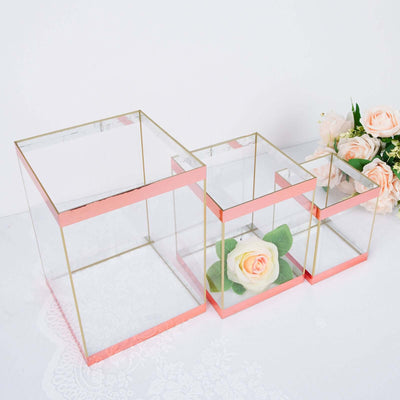 Set of three clear glass boxes with rose gold trim, featuring floral accents.