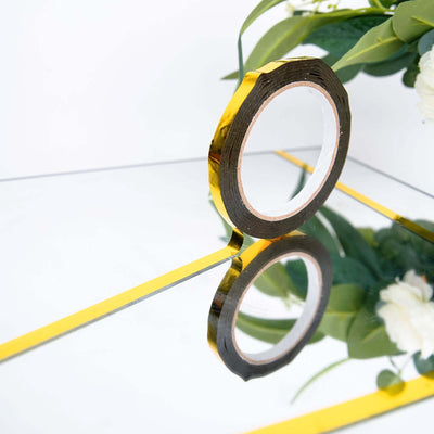 Gold reflective tape roll with a mirror effect and floral arrangement.