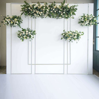 Elegant floral backdrop with white roses and greenery for events and photography.