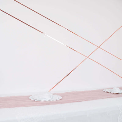 Decorative rose gold lines on a soft pink table runner with white plates.