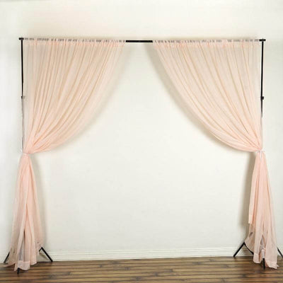 Pink sheer curtains on a black backdrop stand for decorative use.