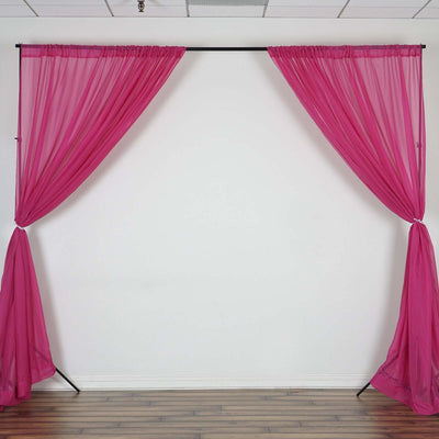 Pink sheer curtains draped on a black stand against a plain white background.