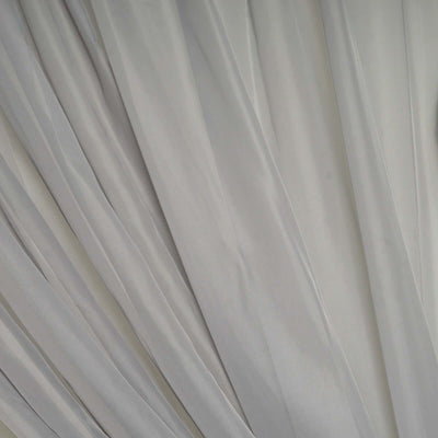 Silver satin fabric draping with soft folds and sheen.