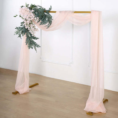 Wedding arch with pink drapes and floral arrangement