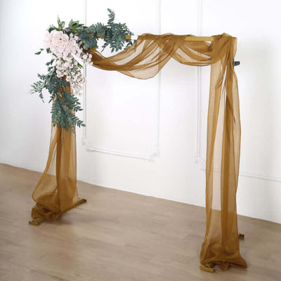Wedding arch with draped fabric and floral arrangement.