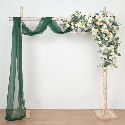 Floral arch with greenery and draped fabric for weddings and events.