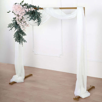 Wedding arch adorned with pink flowers and draped fabric