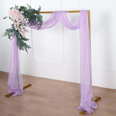 Purple draped wedding arch with floral arrangement