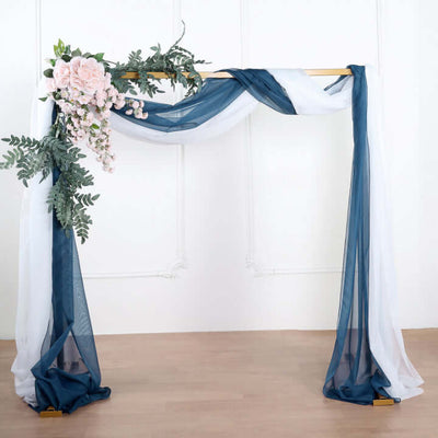 Elegant fabric wedding backdrop with floral accents and drapes.