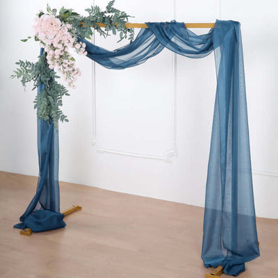 Wedding arch draped with blue fabric and floral accents
