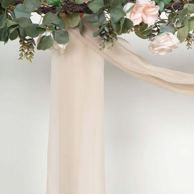 Floral arrangement with soft fabric draping in neutral tones