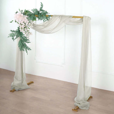 Wedding arch with draped fabric and floral accents.