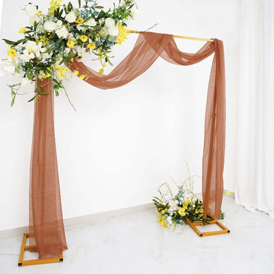 Wooden wedding arch with draped fabric and floral arrangements