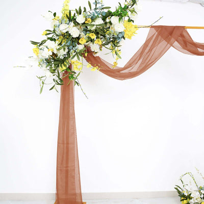 Floral arrangement with yellow and white flowers on a draped backdrop