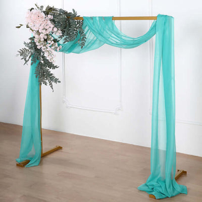 Decorative wedding arch with teal drapes and floral arrangement