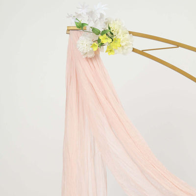 Pink fabric draped with floral accents on a golden stand