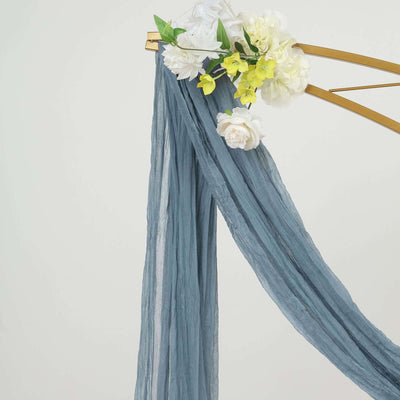 Blue draped fabric with artificial flowers on a gold frame