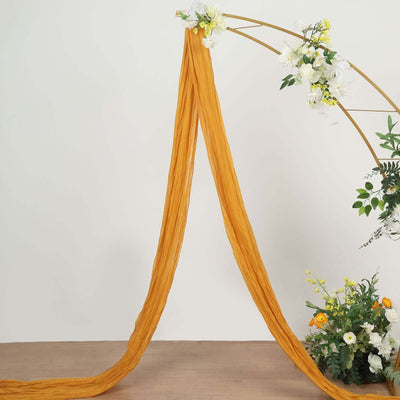 Rust-colored chiffon fabric draped elegantly in a floral arch setup.