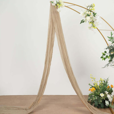 Neutral draping fabric with floral arch and arrangement, perfect for events or decor.