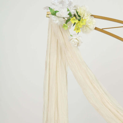 Breezy cream drapery with floral accents on a gold arch
