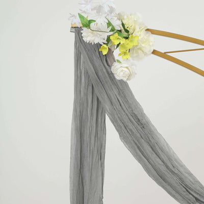 Gray draped fabric with artificial flowers on a gold frame