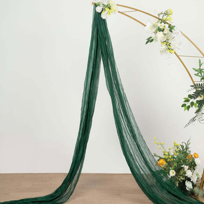 Green sheer fabric draping elegantly from a floral arch.