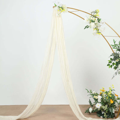 Cream sheer fabric draped elegantly on an arch with floral accents.