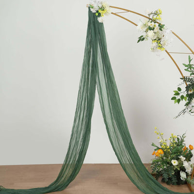 Green sheer fabric draped elegantly, perfect for floral arrangements or decor.