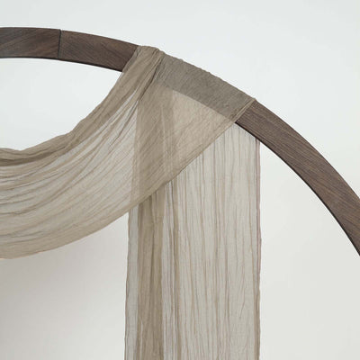 Sheer taupe fabric draped over a wooden frame