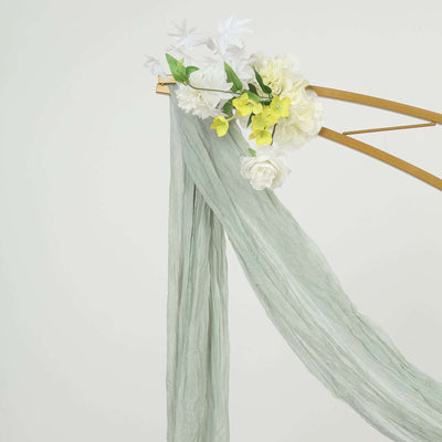Floral backdrop with green fabric draping elegantly on a gold frame