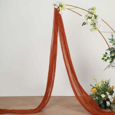 Rust-colored sheer fabric draping elegantly in a floral arrangement.