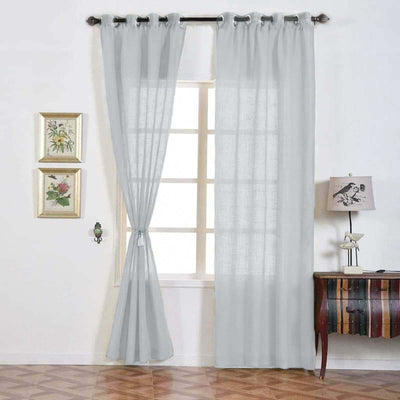 Sheer gray curtains hanging in a bright room with decorative elements.