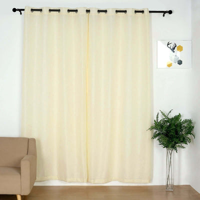 Light yellow sheer curtains hanging in a living room with a sofa and plant.