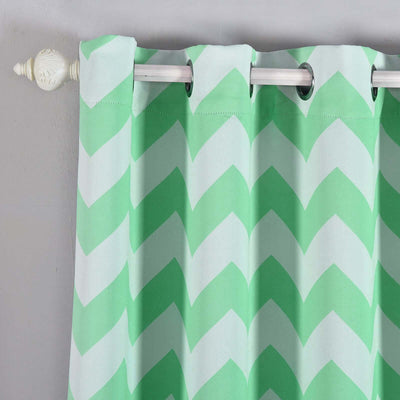 Green chevron patterned curtain hanging on a rod.