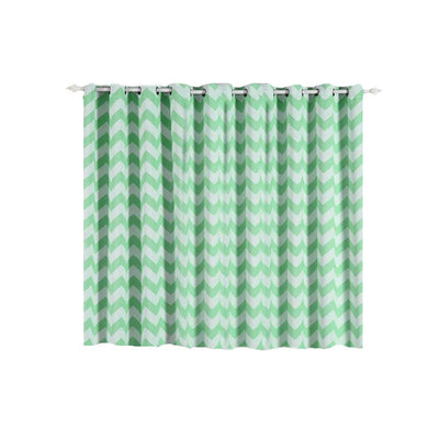 Green chevron patterned curtain hanging from a silver curtain rod