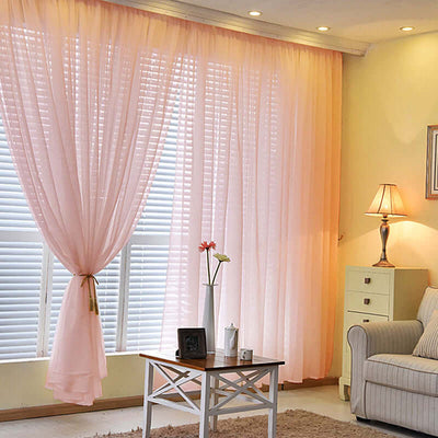 Soft pink sheer curtains elegantly draping a bright window in a cozy living room.